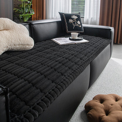 Black plush dog bed mat used as a sofa cover at home