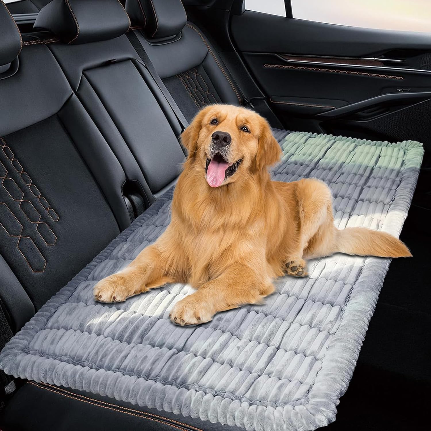 Golden retriever lying on a grey plush dog bed covering the back seat of a car