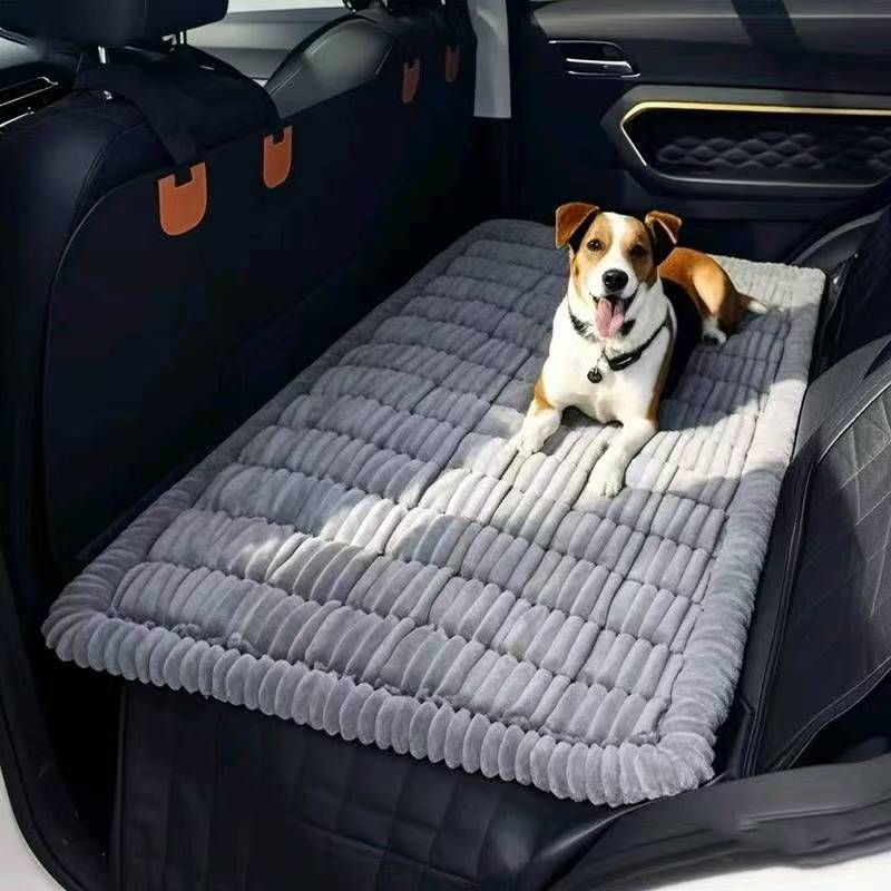 Jack Russell terrier resting on a grey plush dog bed fitted over a black car back seat extender